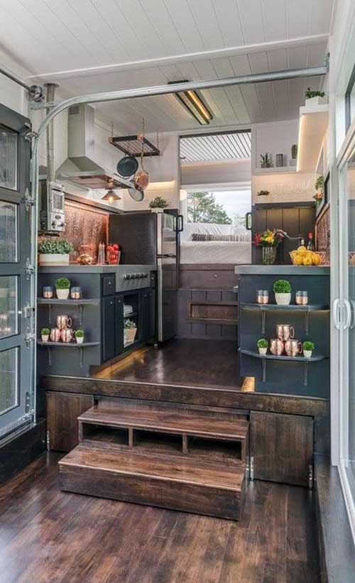 This tiny house kitchen floorplan includes a raised platform, deep blue-grey and dark oak color scheme, and cheerful pops of white and green.