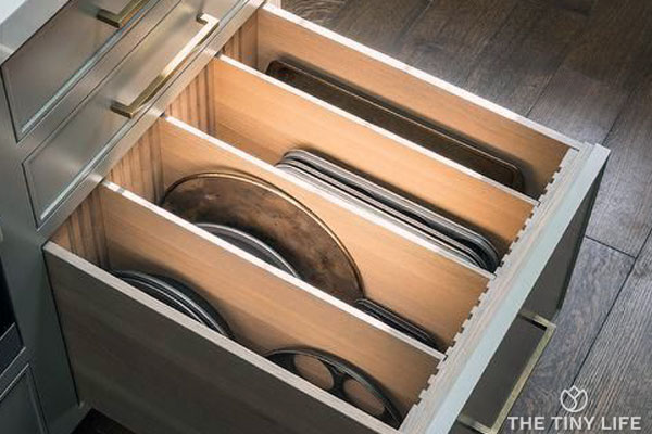 Sheet pans, lids, and flat items are easy to organize using vertical storage in a divided drawer.
