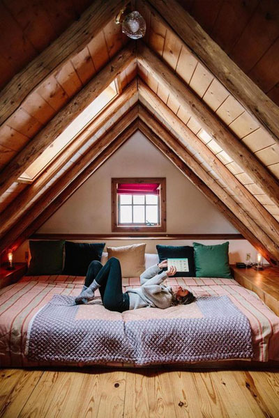 This A-frame loft has enough room for a substantial king-sized bed — the perfect spot for reading a book.
