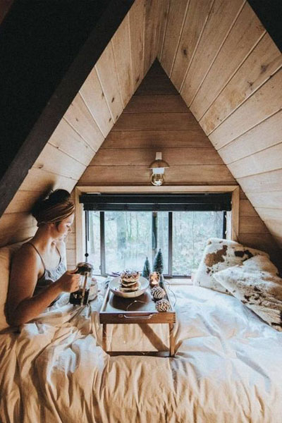 A tray table makes an A-frame loft a perfect place to enjoy breakfast in bed.