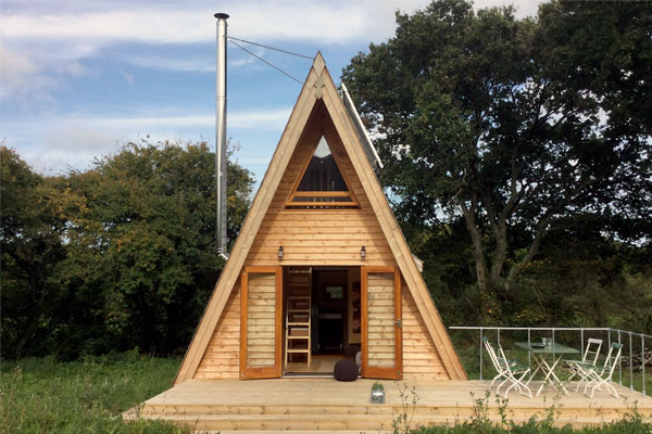 This wooden A-frame tiny house with a dining porch is a basic design but offers ample room.
