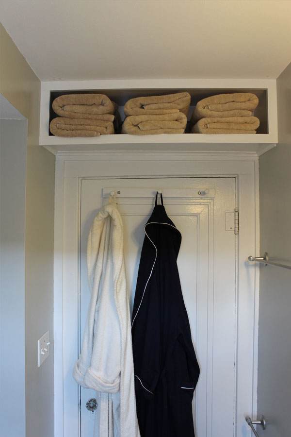 bathroom towels stored above door