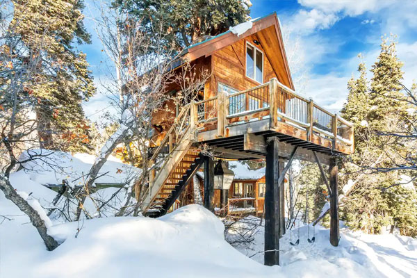 tiny house on pillars in snowy mountains