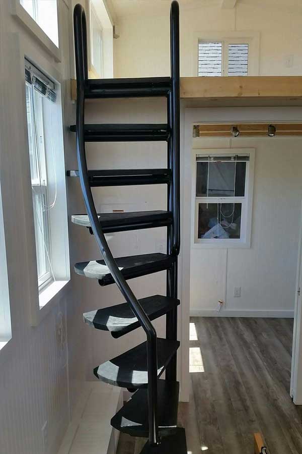 Tiny house boosts living space with motorized deck and spiral staircase